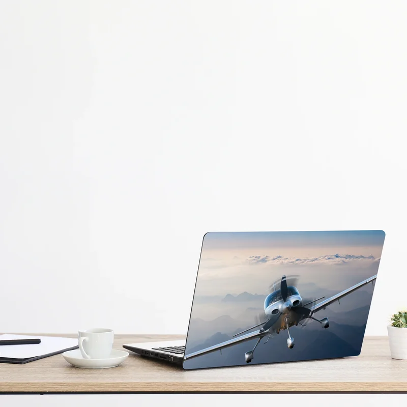 Laptop-Aufkleber silbernes propellerflugzeug über nebeligen bergen Laptop-Aufkleber silbernes propellerflugzeug über nebeligen bergen
