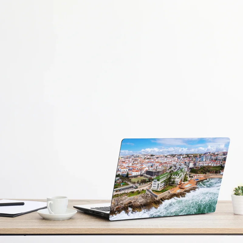 Naklejka na laptopa widok z lotu ptaka na nadmorskie miasteczko z falami Naklejka na laptopa widok z lotu ptaka na nadmorskie miasteczko z falami