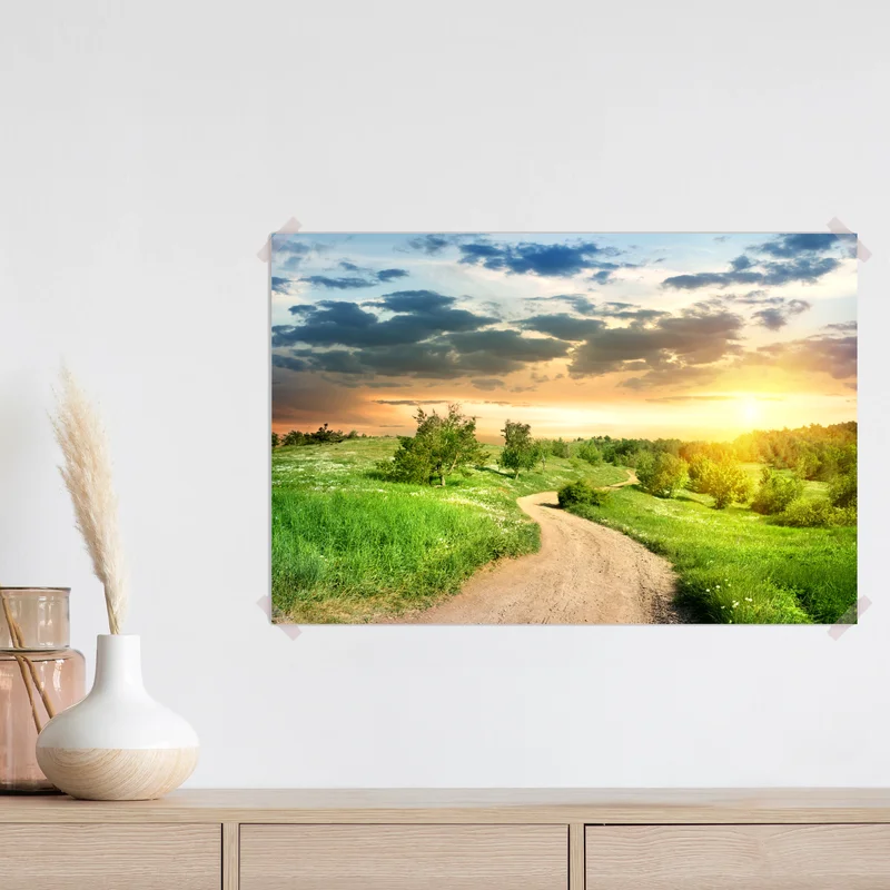 Poster sonnenuntergang über einem feldweg durch grüne wiese Poster sonnenuntergang über einem feldweg durch grüne wiese