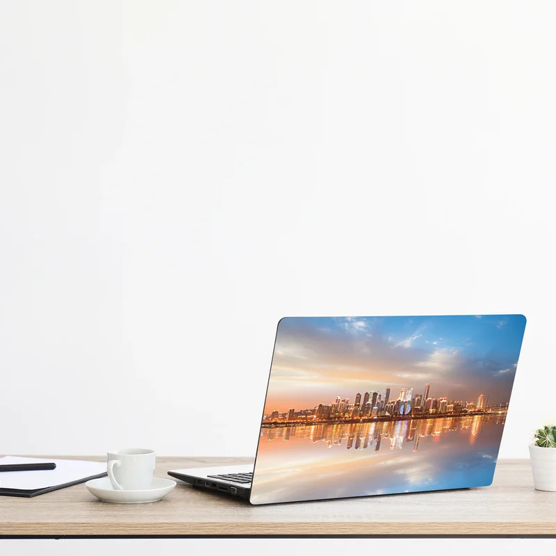 Naklejka na laptopa panorama miasta odbita w wodzie o zmierzchu