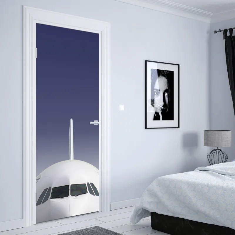 Türaufkleber frontansicht eines flugzeugs vor blauem himmel