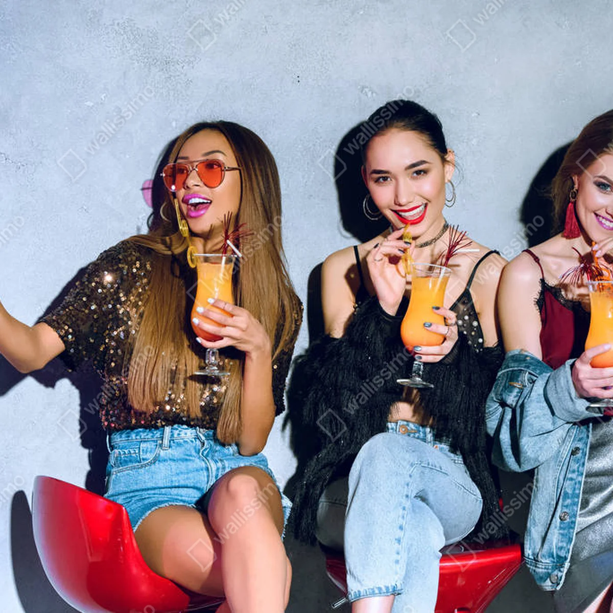 Leinwandbild glücklich stylische multiethnische Mädchen sitzen auf Barhockern und trinken Cocktails auf einer Party • Leinwandbilder bei Wallnifity® Leinwandbild glücklich stylische multiethnische Mädchen sitzen auf Barhockern und trinken Cocktails auf einer Party • Leinwandbilder bei Wallnifity®