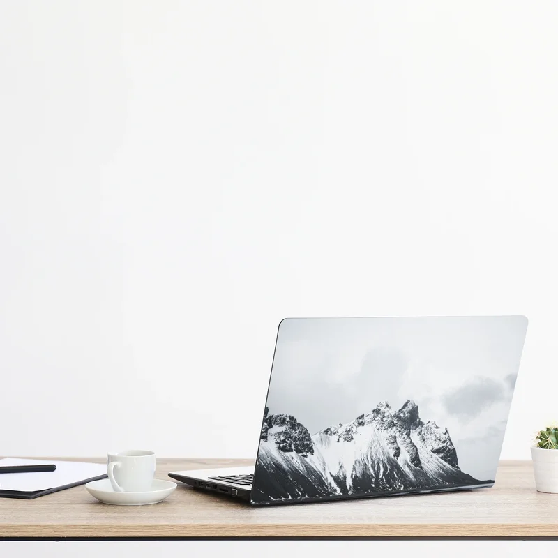 Naklejka na laptopa spokojny ośnieżony krajobraz górski nad morzem