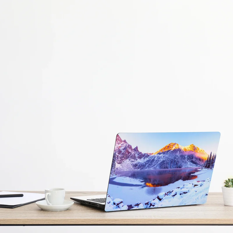 Naklejka na laptopa góry skąpane w świetle wschodu nad zamarzniętym jeziorem