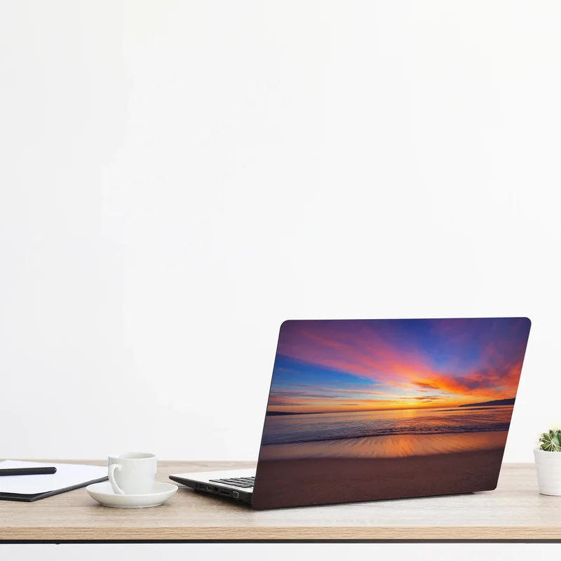 Naklejka na laptopa żywy wschód słońca nad spokojną plażą