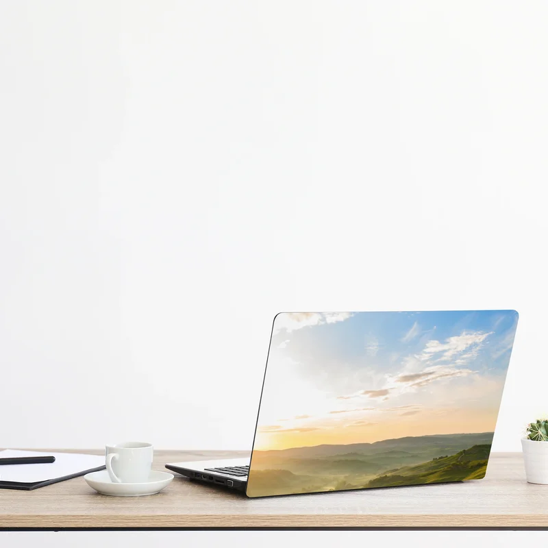 Naklejka na laptopa wschód słońca nad mglistymi pagórkami