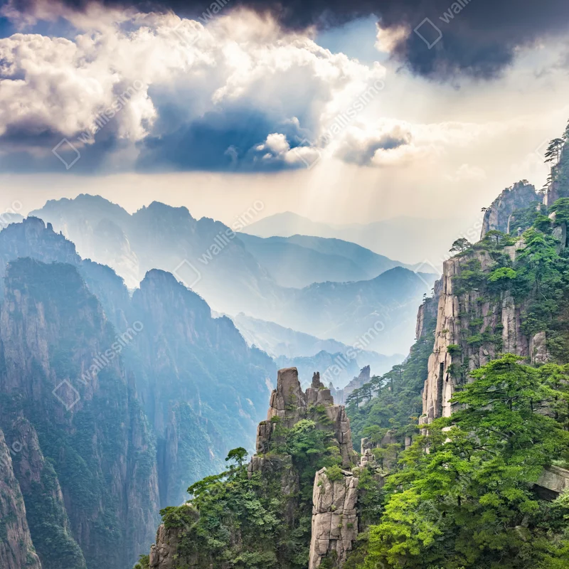 Naklejka na laptopa mglista sceneria górskich klifów z promieniami słońca Naklejka na laptopa mglista sceneria górskich klifów z promieniami słońca