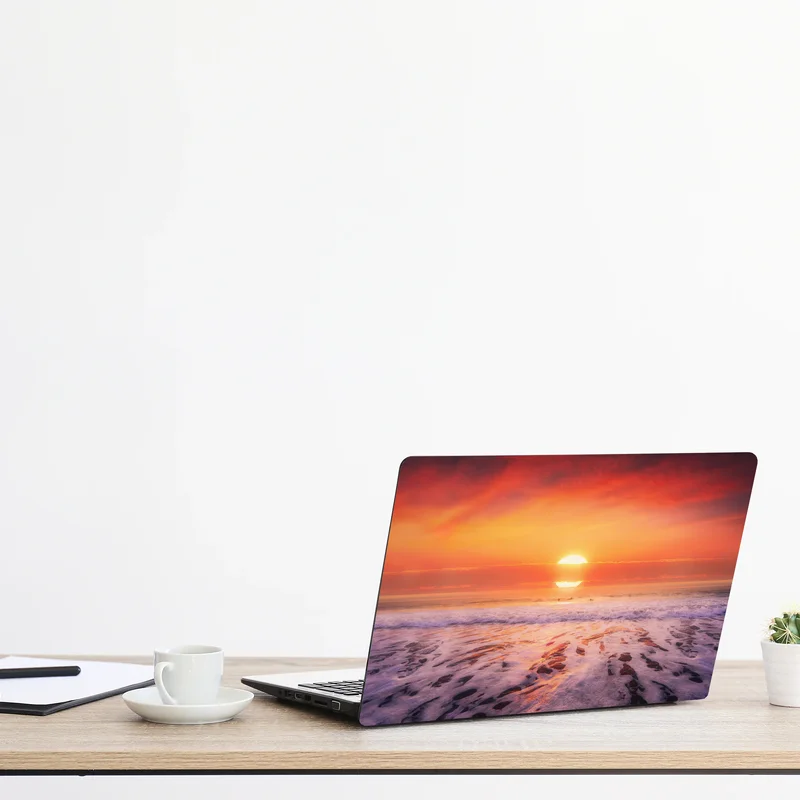 Naklejka na laptopa złoty zachód słońca nad spokojną plażą