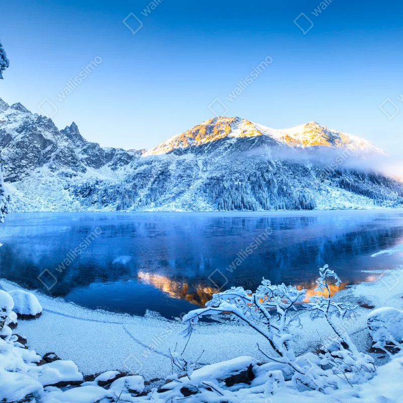 Fototapete winterlicher sonnenaufgang über dem gefrorenen bergsee Fototapete winterlicher sonnenaufgang über dem gefrorenen bergsee