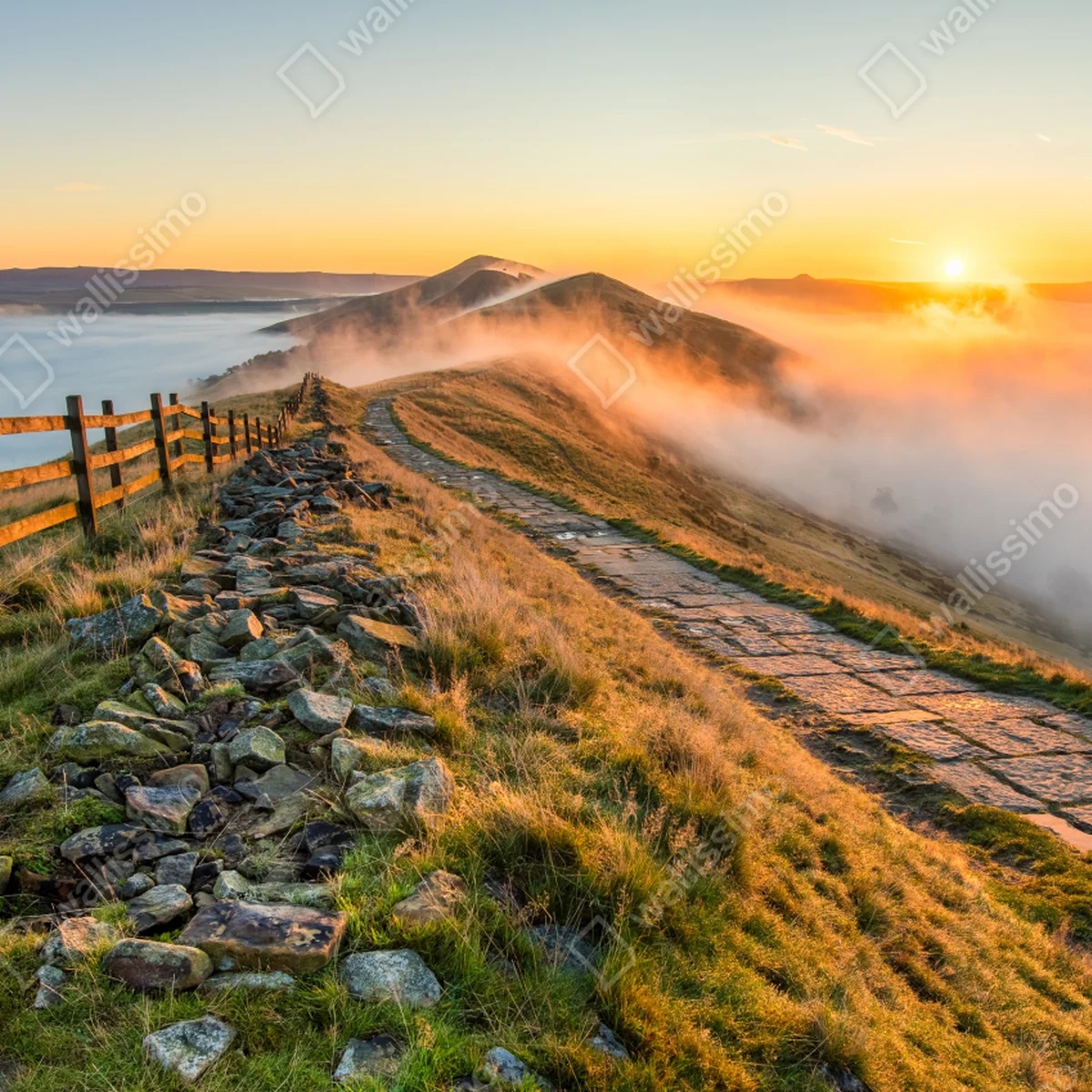 Leinwandbild sonnenaufgang über einem nebligen bergrücken mit steinweg Leinwandbild sonnenaufgang über einem nebligen bergrücken mit steinweg