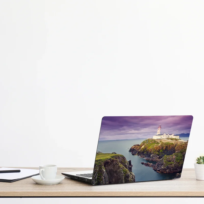 Naklejka na laptopa fioletowa latarnia nad skalistym wybrzeżem Naklejka na laptopa fioletowa latarnia nad skalistym wybrzeżem