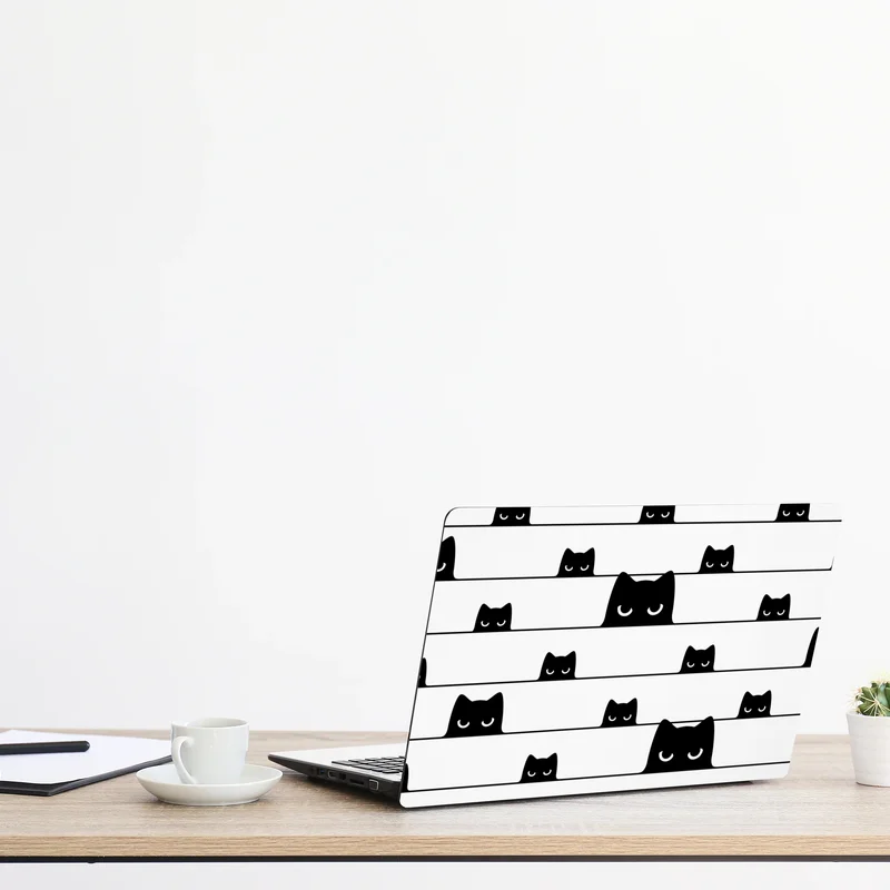 Naklejka na laptopa figlarne koty wyglądające zza pasków