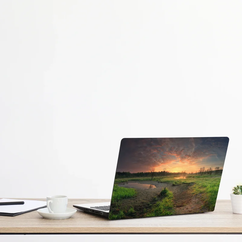 Naklejka na laptopa zachód słońca nad spokojną łąką